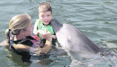 Ein Delfin schmust mit Timon im warmen Wasser Floridas. Die Therapeutin war stets in der N&auml;he des Jungen aus &Ouml;hringen. (Foto: privat)