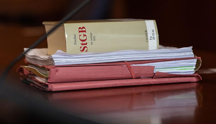 Das Strafgesetzbuch und Akten liegen in einem Gericht auf dem Tisch. Das Strafgesetzbuch und Akten liegen in einem Gericht auf dem Tisch.