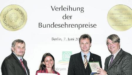 DLG-Präsident Philipp Freiherr von dem Bussche re.) überreicht mit Staatssekretär Dr. Gerhard Thalheim (li.) die Auszeichnung an Tanja Denz und Ralph Dausch.