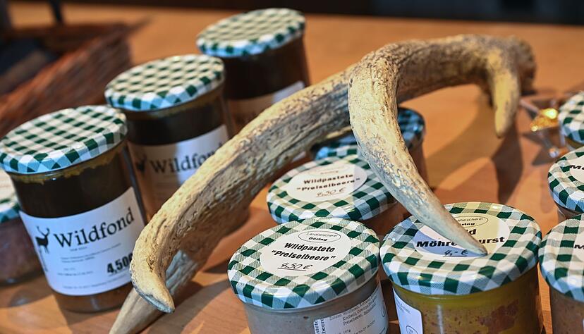 Wild-Fond und Wildpastete in Gläsern liegen im Wildladen neben einem Geweih. Wild-Fond und Wildpastete in Gläsern liegen im Wildladen neben einem Geweih.