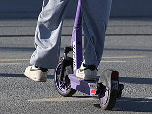 Ein junger Mann f&auml;hrt einen E-Scooter durch die Stadt. (Symbolbild)
