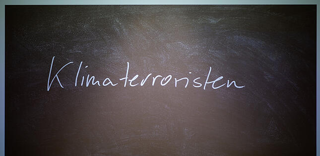 Das «Unwort des Jahres» 2022, «Klimaterroristen», wird an der Philipps-Universität vor seiner Bekanntgabe an eine Wand projiziert. Die Jury der sprachkritischen Aktion kritisiert mit dem Ausdruck die Gleichsetzung von Klimaaktivisten mit Terroristen. +++ dpa-Bildfunk +++