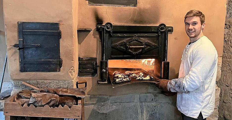 Tobias Gerne lernt auf dem Forchtenberger Weihnachtsmarkt, wie im Holzbackofen Fladen gemacht werden.