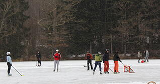 Eisl&auml;ufer auf dem Neum&uuml;hlsee in Waldenburg ziehen sich eine Bahn und nutzen den zugefrorenen See zum Eishockeyspielen, einfach so zum Laufen oder ziehen den Schlitten &uuml;ber die Bahn. Foto: Stefanie Jani