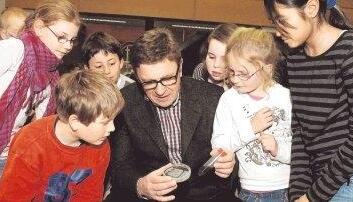 Bakterien sind so winzig, dass Menschen sie nicht sehen können. Nur ganze Haufen von ihnen lassen sich erkennen. Karl Forchhammer zeigt den Kindern im Labor gezüchtete Bakterienkolonien aus Milliarden Exemplaren. Foto: Dittmar Dirks
