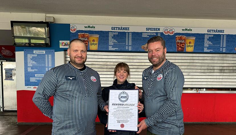 Das Catering-Team des Ostseestadions Rostock um Gesch&auml;ftsf&uuml;hrer Christoph Wulff (r) und K&uuml;chenchef Jens Schaumburg (l) hat das l&auml;ngste Fischbr&ouml;tchen der Welt produziert. Best&auml;tigt wurde der Rekord von Laura Koblischek (M) vom Rekord-Institut Deutschland. (Foto Handout)