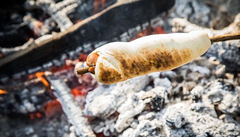 Wenn der Teig nicht allein um den Knüppel, sondern auch mit um ein Würstchen gewickelt wird, wird aus dem Stockbrot ein Hotdog.