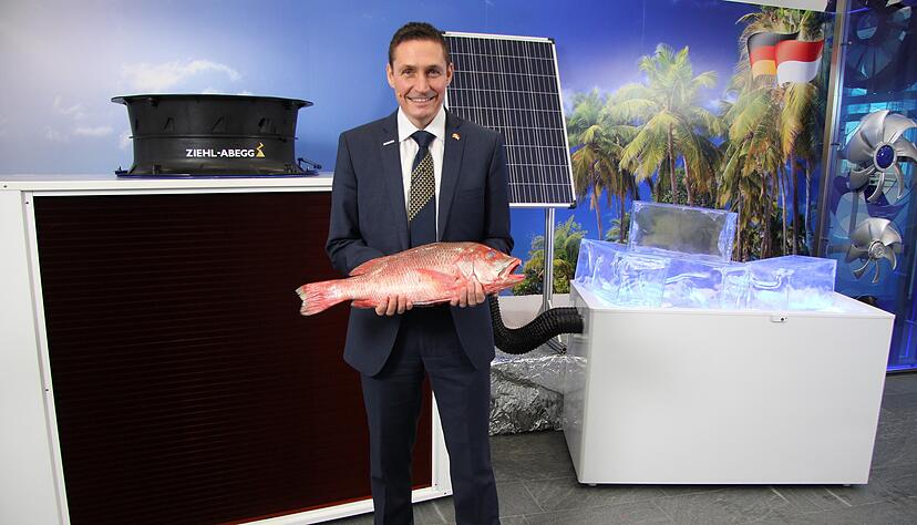Steffen Sinn, bei Ziehl-Abegg verantwortlich f&uuml;r den Verkauf in Asien, mit einem Red Snapper vor der Eismaschine, die mit Solarenergie funktioniert.
Foto: Ziehl-Abegg