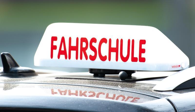 Ein Schild mit der Aufschrift «Fahrschule» ist auf einem Fahrschulauto befestigt.