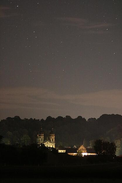 Die Klosterkirche in Schöntal unterm Sternenhimmel. Der Platz davor wird von einer Laterne beleuchtet, deswegen ist das Gebäude so hell.