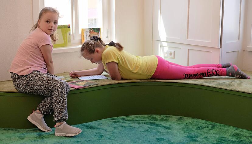 Arina (links) und Sofia Lich sind Stammg&auml;ste in der B&uuml;cherei. Mindestens einmal im Monat kommen sie mit ihrer Mama zum Schm&ouml;kern und B&uuml;cherausleihen.