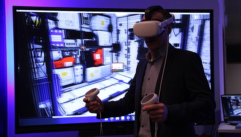 Stadtrat Ralf Werner schaut sich mit Hilfe einer VR-Brille auf der Internationalen Raumstation um.