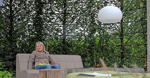 Rosemarie Messer sitzt auf dem Sofa, f&uuml;r das sie sich interessiert. Davor liegt der Teppich, den sie bereits gekauft hat.Fotos: Renk (1)/Tscherwitschke (3)