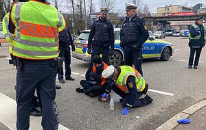 Ein Polizist löst die Hand eines Aktivisten.