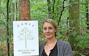 Diana Gleiter zeigt das Schild, das allen Helfern und Sponsoren gewidmet ist.