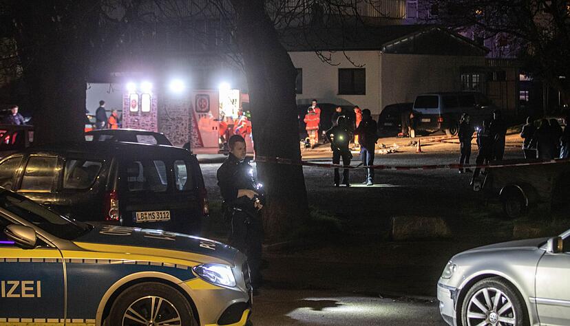 Polizisten suchen nach Spuren während Rettungssanitäter noch am Tatort arbeiten.