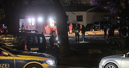 Polizisten suchen nach Spuren während Rettungssanitäter noch am Tatort arbeiten.