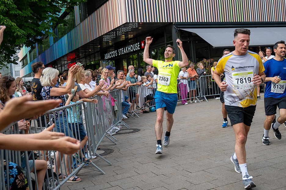 Neben der Strecke jubeln Zuschauer den Läufern beim Stimme-Firmenlauf durch Heilbronn zu. Neben der Strecke jubeln Zuschauer den Läufern beim Stimme-Firmenlauf durch Heilbronn zu.