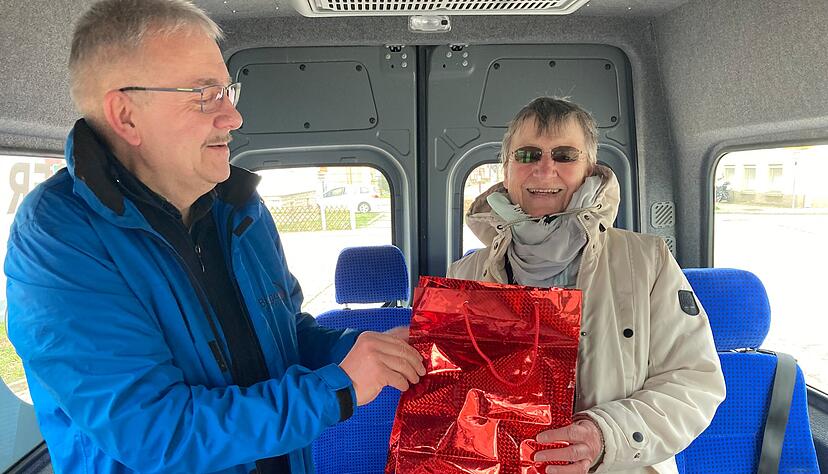 Klaus Ries-M&uuml;ller &uuml;berreicht Brunhilde Wachno als erstem Fahrgast ein Geschenk.