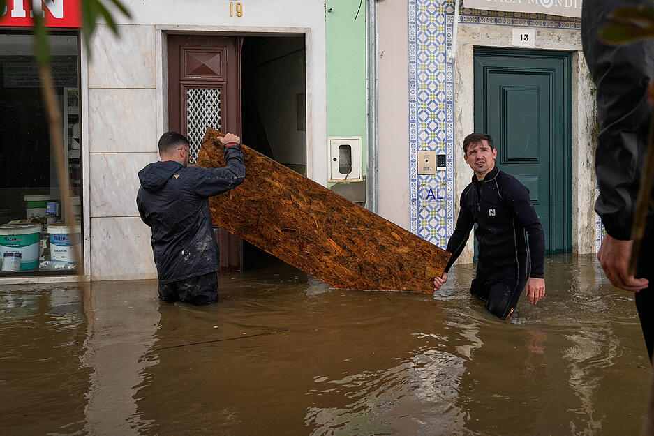 Anwohner errichten Barrikaden, um zu verhindern, dass Wasser in bereits &uuml;berschwemmte H&auml;user eindringt, nachdem der Fluss Sado infolge starker Regenf&auml;lle in Alcacer do Sal in S&uuml;dportugal &uuml;ber die Ufer getreten ist.