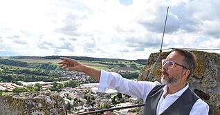 Christoph Behr weist vom Burgturm in Richtung Wiesen jenseits der Jagst. Von dort kamen die Dragoner zum Kaiser-Manöver angestürmt.