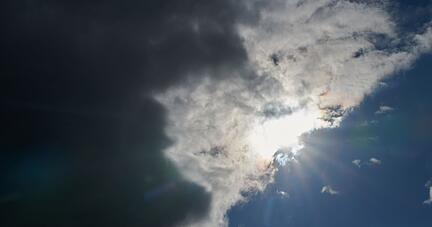Die Sonne kommt hinter Regenwolken hervor.