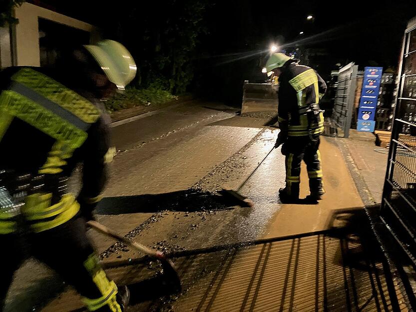 Einsatzkräfte und Anwohner sind auch zu später Stunde mit Säuberungsarbeiten beschäftigt.