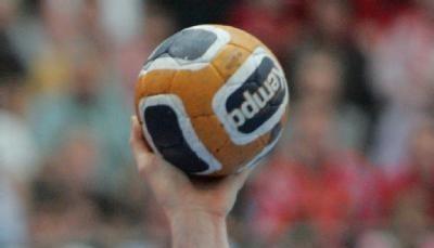 Ein Handballspieler hält den Ball zum Wurf erhoben.