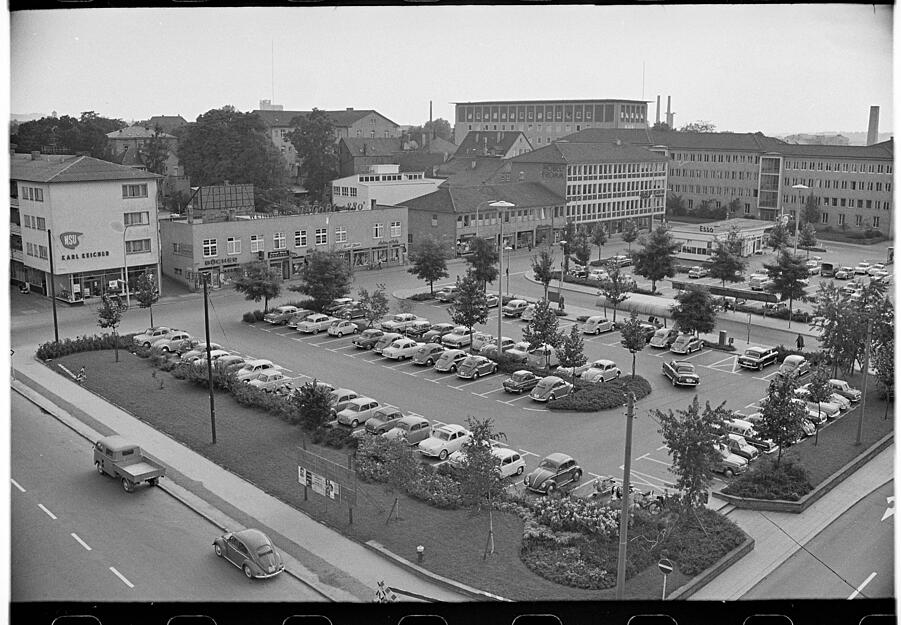 August 1961. Der Parkplatz wird rege genutzt. Das Gebäude im Hintergrund rechts beherbergt Amts- und Landgericht, davor ist das Möbelhaus Fromm sichtbar.