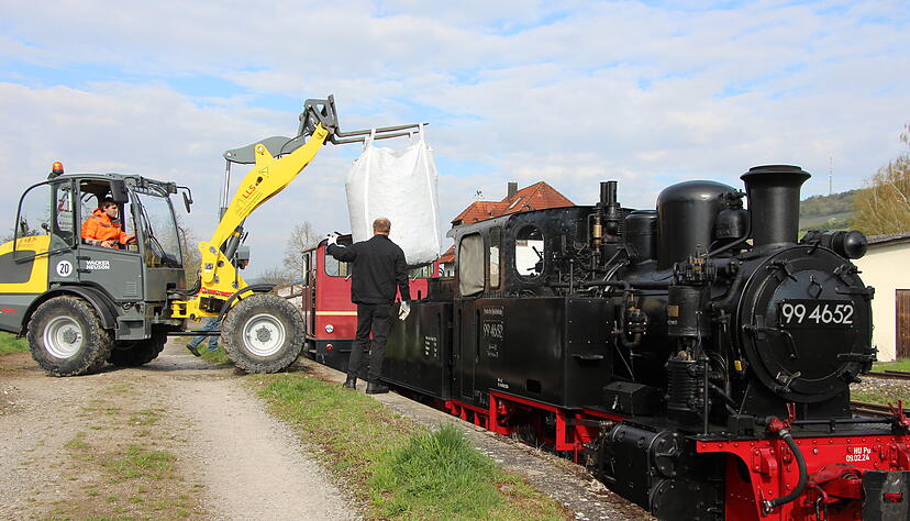 Die Jagsttalbahnfreunde bef&uuml;llen den sogenannten Tender mit Kohle.