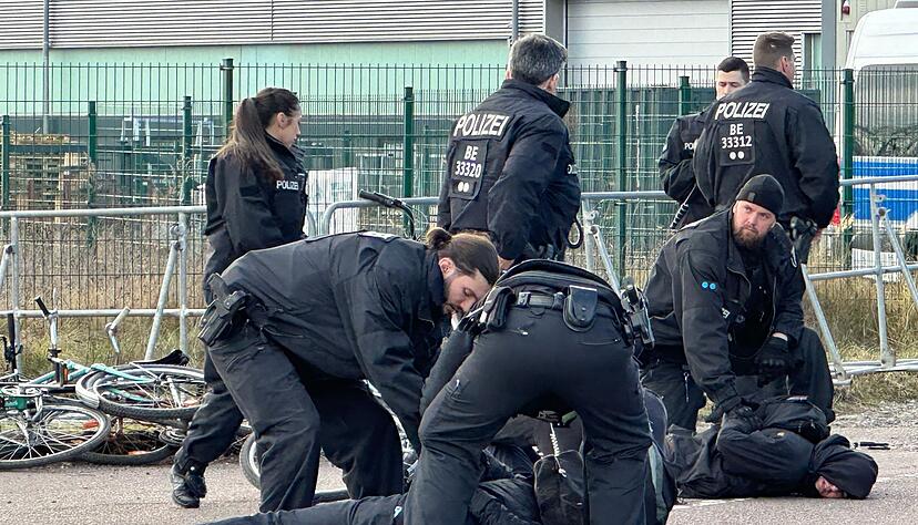 Polizisten halten Demonstranten am Boden fest. Sie hatten zuvor versucht mit Fahrr&auml;dern Richtung Veranstaltungshalle vorzudringen.
