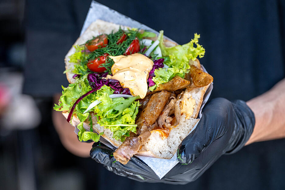 Serviert wird der D&ouml;ner in verschiedenen Brotvarianten mit Lollo Bianca und Rosso-Salaten, Cherry-Tomaten, Zwiebel-Petersilien-Gemisch, Rotkraut-Spezialmischung und Kr&auml;uter-Knoblauch Sauce.