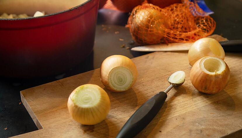 Mit einem Parisienne-Löffel oder einem Kugelausstecher wird die ungeschälte Zwiebel ausgehöhlt. Mit einem Parisienne-Löffel oder einem Kugelausstecher wird die ungeschälte Zwiebel ausgehöhlt.
