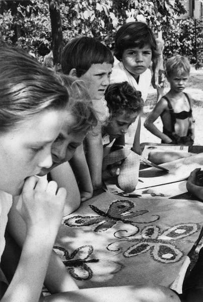 August 1963: Mit großer Hingabe basteln und malen Mädchen und Jungs unter Bäumen. August 1963: Mit großer Hingabe basteln und malen Mädchen und Jungs unter Bäumen.