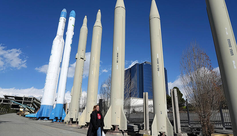 Eine Frau geht in einem Erholungsgebiet im Norden Teherans an den im Iran produzierten Raketen und Satellitentr&auml;gern vorbei, die in einer Dauerausstellung gezeigt werden.