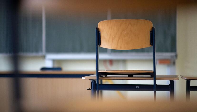 Ein Stuhl steht in einem Klassenzimmer auf dem Tisch.
