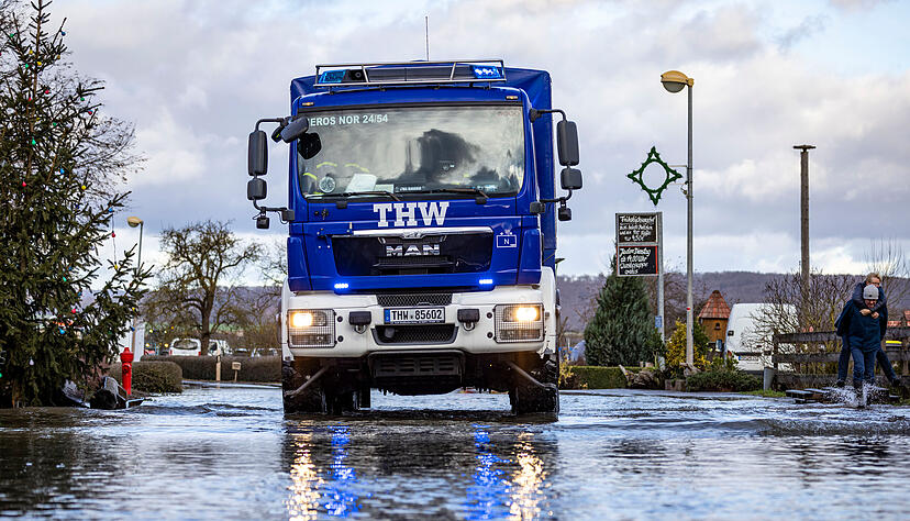 Ein Fahrzeug des THW fährt über eine überschwemmte Straße in Windehausen. Die Hochwasserlage in dem überfluteten und weitgehend geräumten Ort in Nordthüringen ist nach Einschätzung der Einsatzkräfte stabil. Entwarnung könne aber noch nicht gegeben werden.