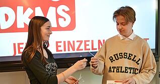 Anna Neubert übergibt ein Set für den Abstrich der Wangenschleimhaut an Silas Georgis. Mit den Analysedaten findet die DKMS geeignete Spender. Anna Neubert übergibt ein Set für den Abstrich der Wangenschleimhaut an Silas Georgis. Mit den Analysedaten findet die DKMS geeignete Spender.