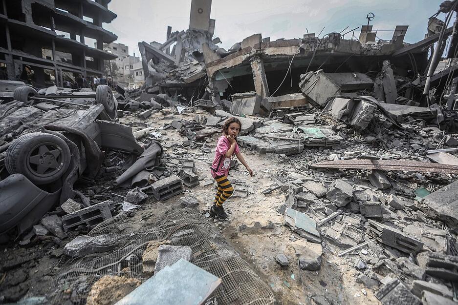 Ein palästinensisches Mädchen geht nach israelischen Luftangriffen auf das Flüchtlingslager Shati in Gaza durch die Trümmer.