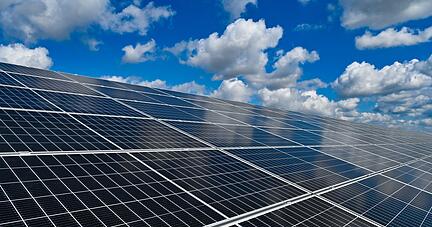 Ein Solarpark unter wolkigem Himmel.