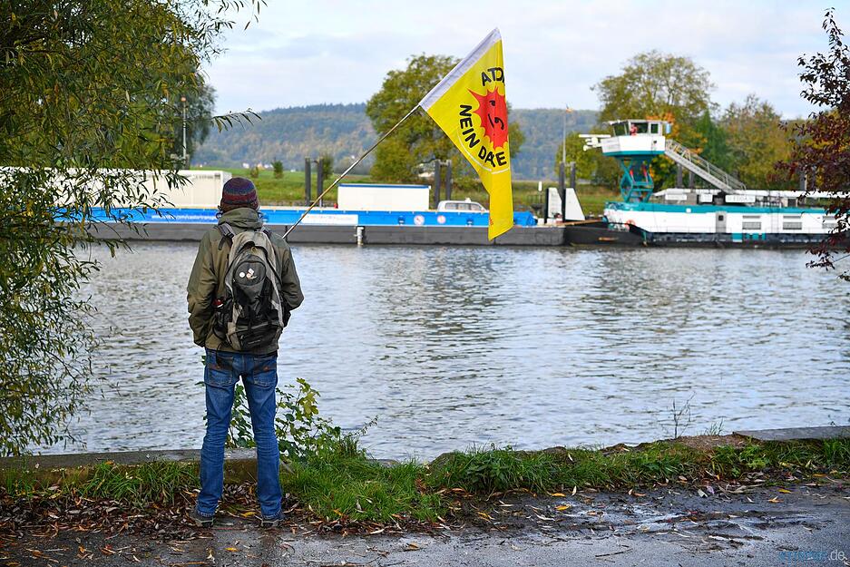 Ein Atomkraftgegner beobachtet in Gundelsheim die Fahrt des Castor-Schiffs.