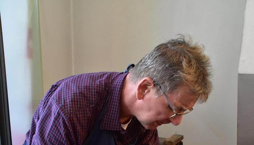 Frank Stransky gie&szlig;t dem kleinen Steffen (6) ein Huhn aus Zinn.