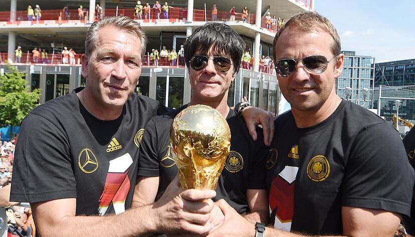 Nach dem WM-Sieg noch gemeinsam auf dem Truck: v.l.: Torwarttrainer Andreas Köpke (Deutschland), Bundestrainer / Trainer Joachim Löw (Deutschland), Assistenztrainer / Co-Trainer Hansi Flick (Deutschland) am 15.07.2014 zur Feier der deutschen Fußball-Nationalmannschaft auf die Fanmeile am Brandenburger Tor in Berlin.
