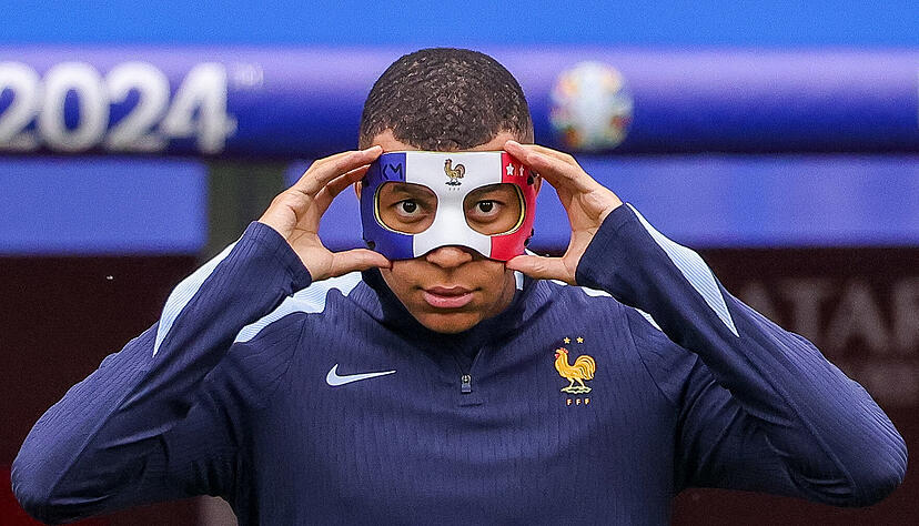 Frankreichs Kylian Mbappe richtet sich seine Maske. Er hatte sich einen Nasenbeinbruch zugezogen, ist aber für das Spiel gegen die Niederlande wohl fit. Frankreichs Kylian Mbappe richtet sich seine Maske. Er hatte sich einen Nasenbeinbruch zugezogen, ist aber für das Spiel gegen die Niederlande wohl fit.