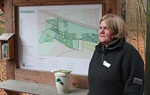 Friedwald-F&ouml;rsterin Annette Pfeiffer vor der Infotafel am Eingang.