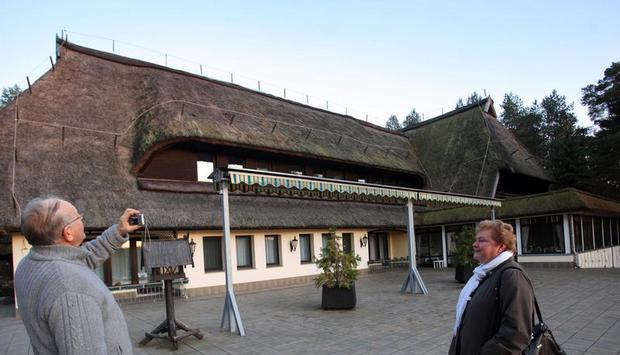 Passanten fotografieren in Drewitz bei Malchow den ehemaligen Jagdsitz von DDR-Staats- und Parteichef Erich Honecker. Archivfoto: Jens Büttner