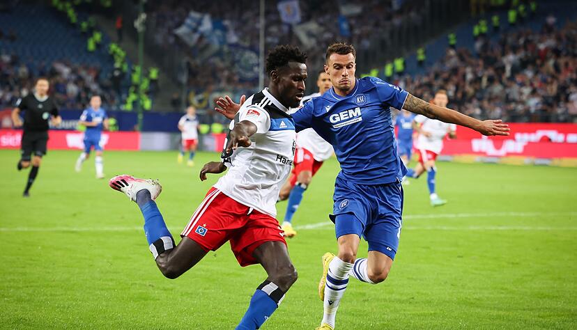 Hamburgs Bakery Jatta (l) versucht gegen und Karlsruhes Philip Heise zu flanken.