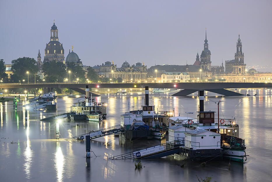 Die Anleger für die Schiffe der Sächsischen Dampfschifffahrt in Dresden sind vom Hochwasser der Elbe umspült. Im Hintergrund ist die Altstadtkulisse und die teilweise eingestürzte Carolabrücke zu sehen.