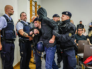 Polizeibeamte führen einen Störer aus der Halle, der die Diskussionsrunde mit Tübingens Oberbürgermeister Palmer (parteilos) und dem AfD-Landesvorsitzenden Frohnmaier in der Hermann-Hepper-Halle gemeinsam mit anderen Demonstranten gestört hatte.
