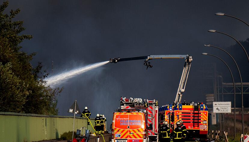 Einsatzkr&auml;fte der Feuerwehr versuchen, einen Brand in einem Industriegebiet im Hamburger Hafen zu l&ouml;schen.